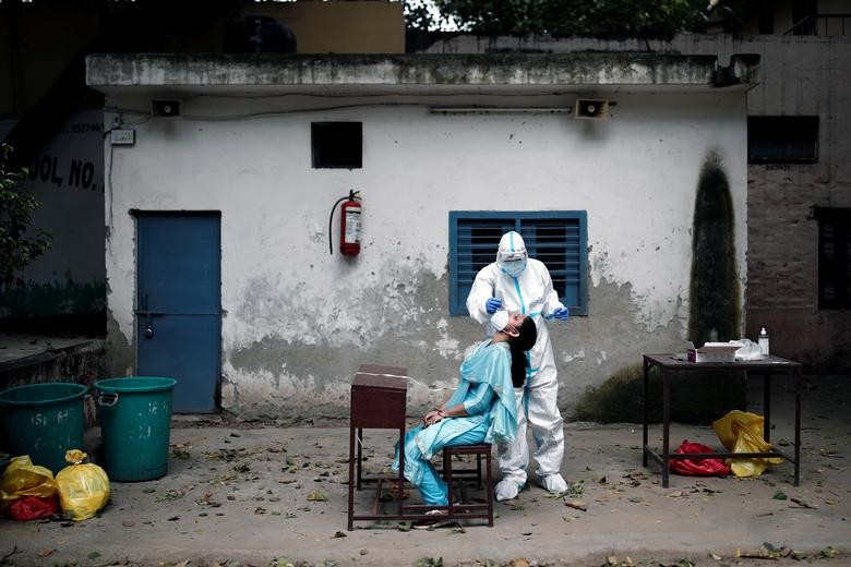 A health worker in personal protective equipment (PPE) collects a sample using a swab from a person at a school which was turned into a centre to conduct tests for the coronavirus in New Delhi, India, August 6. REUTERS/Adnan Abidi